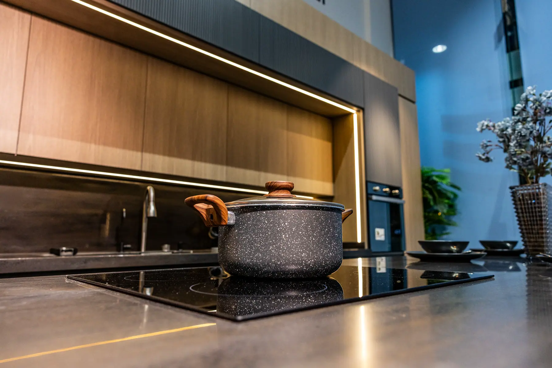 Dark worktop and hob with concealed lighting under the wall units